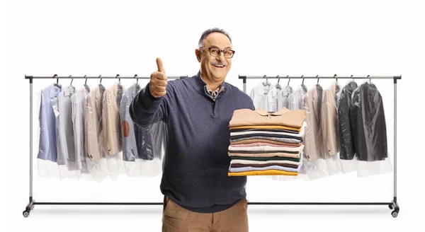 Cheerful Mature Man Holding Pile Folded Clothes Gesturing Thumbs Front — Stock Photo, Image
