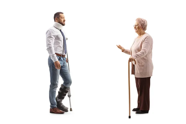 Full Length Profile Shot Elderly Woman Talking Young Injured Man — Stock Photo, Image