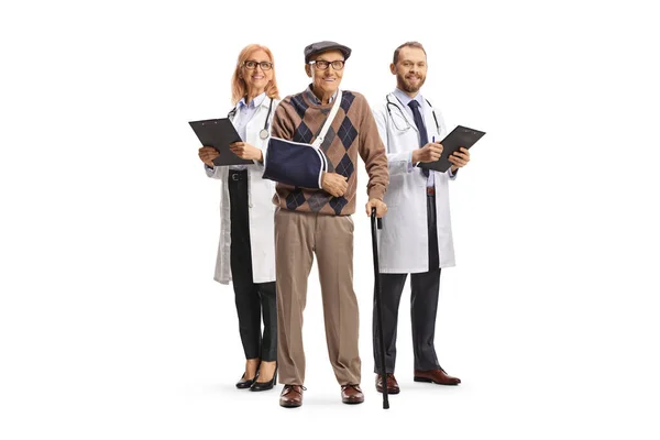 老年男性患者 手臂骨折 站在因白人背景而隔离的男医生和女医生面前 — 图库照片