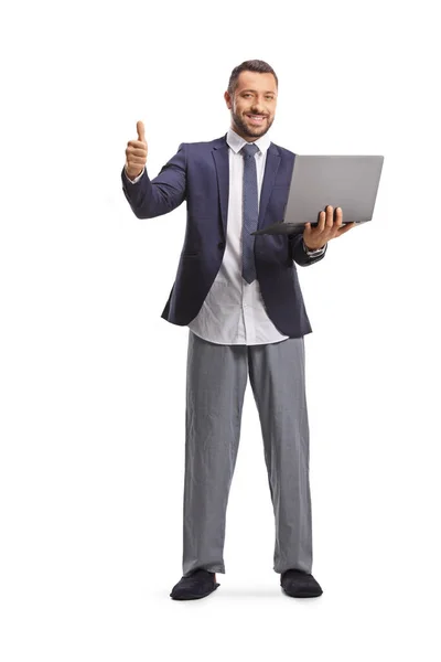 一个身穿西服 身穿底睡衣 手持笔记本电脑 用白色背景隔离的大拇指的男人的全长肖像 — 图库照片