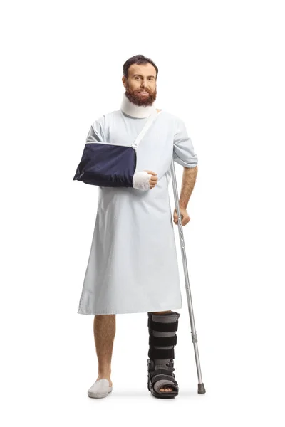 Bärtiger Mann Krankenhauskleid Mit Gebrochenem Bein Arm Und Hals Isoliert — Stockfoto