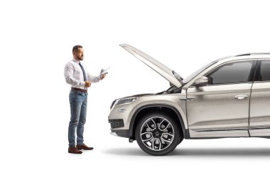 Beyaz arka planda izole edilmiş bir SUV 'un motor yağını kontrol eden bir iş adamının tam boy profil çekimi.