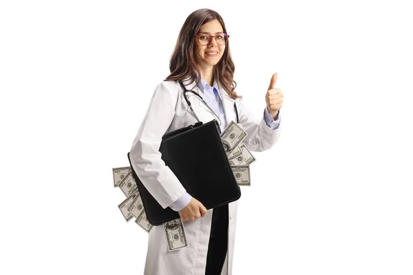 Νεαρή Γυναίκα Γιατρός Κρατώντας Ένα Χαρτοφύλακα Χρήματα Και Gesturing Αντίχειρες — Φωτογραφία Αρχείου