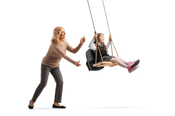 Vrouw Duwen Een Schoolmeisje Een Swing Geïsoleerd Witte Achtergrond — Stockfoto