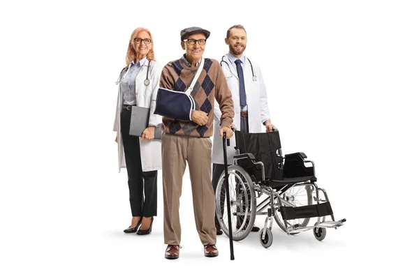 白い背景に孤立した腕を持つ高齢男性患者の後ろに車椅子を持つ医師 — ストック写真