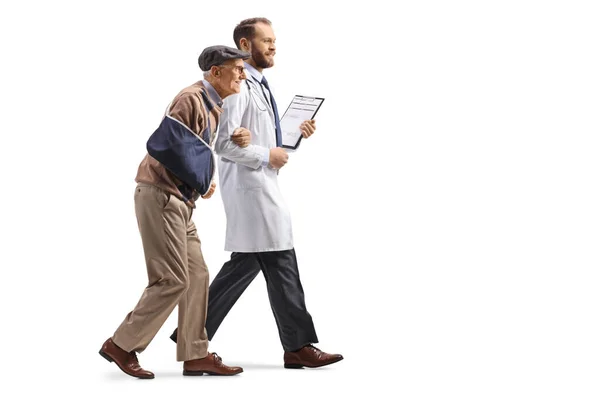 医生和老年患者 一只受伤的手臂在一起行走 被白色背景隔离 — 图库照片