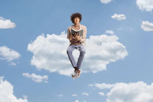 Jovem Com Cabelo Encaracolado Sentado Uma Nuvem Segurando Livro Céu — Fotografia de Stock