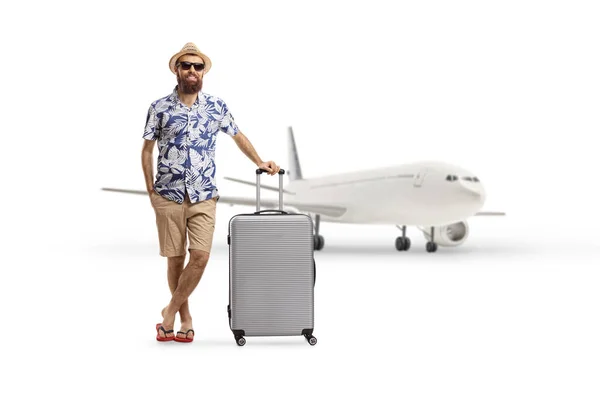 白い背景に隔離された航空機の前でスーツケースを着た観光客の完全な長さの肖像画 — ストック写真