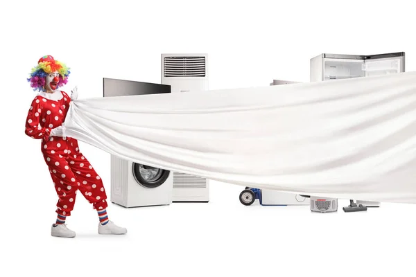 小丑拉着一块白色的大布在白色背景隔离的电器前 — 图库照片