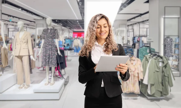 Businesswoman using a digital tablet inside a clothing store