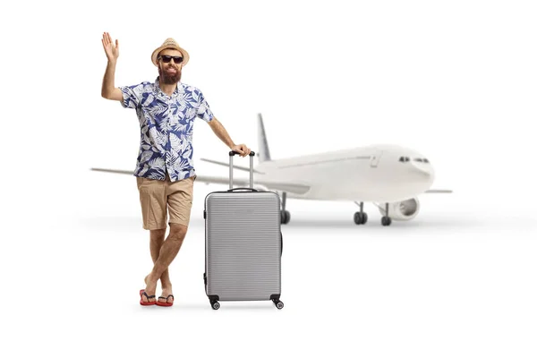 飛行機の前にスーツケースを背負った観光客のポーズと白い背景に孤立した手を振っての完全な長さの肖像画 — ストック写真
