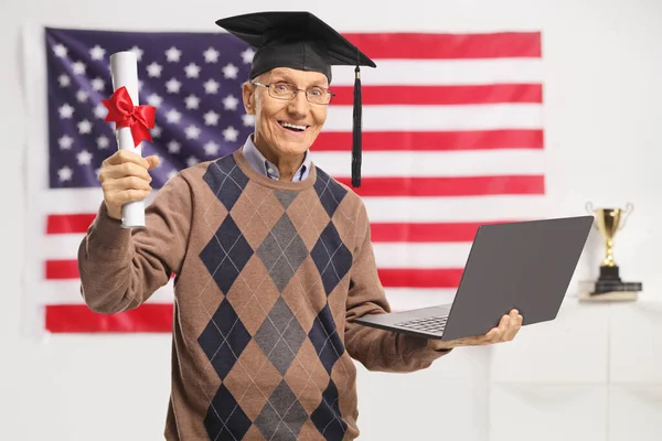 Älterer Mann Mit Abschlusszeugnis Und Laptop Vor Einer Flagge — Stockfoto