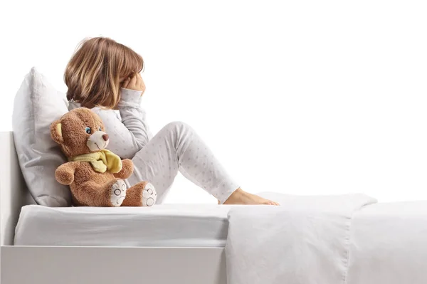 Pijamalı Üzgün Çocuk Beyaz Arka Planda Yalnız Bir Yatakta Oturuyor — Stok fotoğraf
