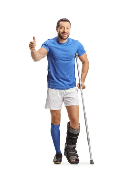一个男子运动员的全长肖像 他有拐杖和一个行走的支架 他的大拇指在白色背景下被隔离 — 图库照片
