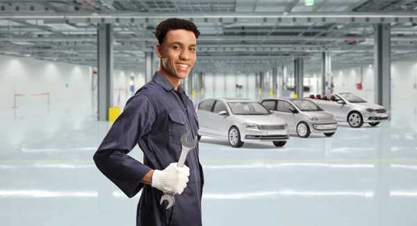 アフリカ系アメリカ人の自動車整備士がガレージにレンチを持ち — ストック写真