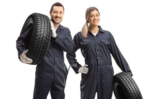 男女汽车修理工 带着用白色背景隔离的轮胎 — 图库照片