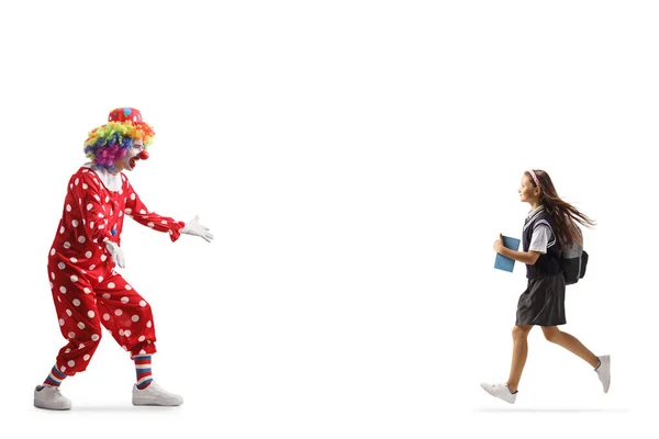穿着校服的女学生跑向一个被白色背带隔开的小丑 — 图库照片