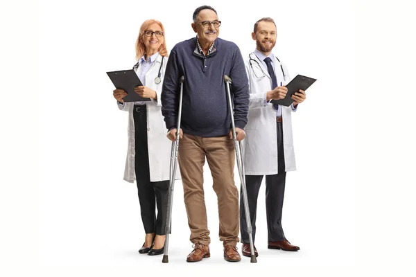 Mature Man Crutches Front Male Female Physicians Isolated White Background — Stock Photo, Image