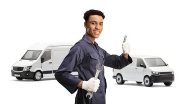 Beyaz arka planda izole edilmiş iki minibüsün önünde duran afro-amerikalı tamirci.