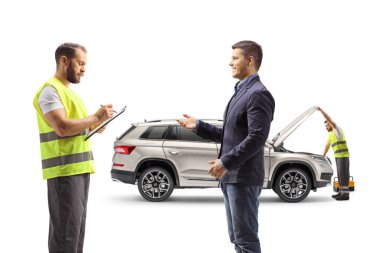 Bozuk arabalı bir adam beyaz arka planda izole edilmiş bir yol işçisiyle konuşuyor.