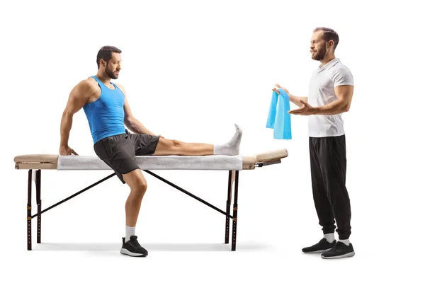 物理治疗师向一位腿受伤的男性运动员展示运动 他的腿被白色背景隔离 — 图库照片
