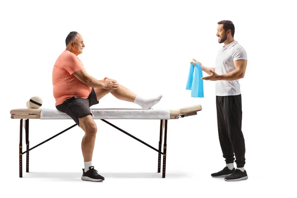 Физиотерапевт Показывает Упражнения Взрослому Мужчине Поврежденным Коленом Белом Фоне — стоковое фото