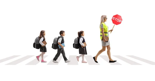 安全ベストの教師と学校の子供たちが通りを横断し 白い背景に隔離された歩行者横断歩道で標識を運ぶ — ストック写真