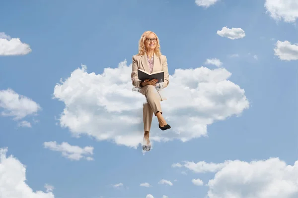 Donna Matura Seduta Una Nuvola Che Legge Libro Nel Cielo — Foto Stock