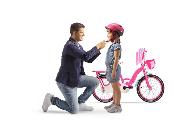 男人把头盔戴在一个女孩身上骑自行车时被白色背景隔离了 — 图库照片