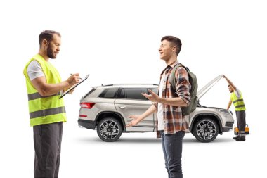 Yol yardımı görevlisi bir belge yazıyor ve erkek öğrenci beyaz arka planda izole edilmiş bir araba sorununu anlatıyor