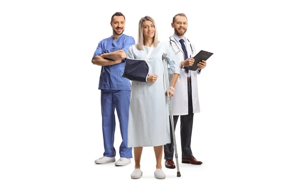 身穿医院长袍的女病人站在因白人背景而被隔离的男性医护人员面前 — 图库照片