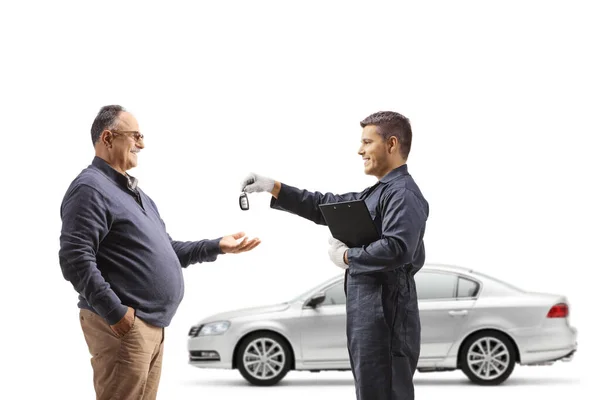 自動車整備士が白地に隔離された成熟した男に車の鍵を返す — ストック写真