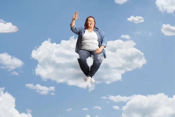 重い若い女性が雲の上に座って手を振って — ストック写真