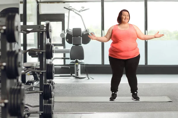穿着运动服在体育馆里摆姿势的快乐而肥胖的女人 — 图库照片