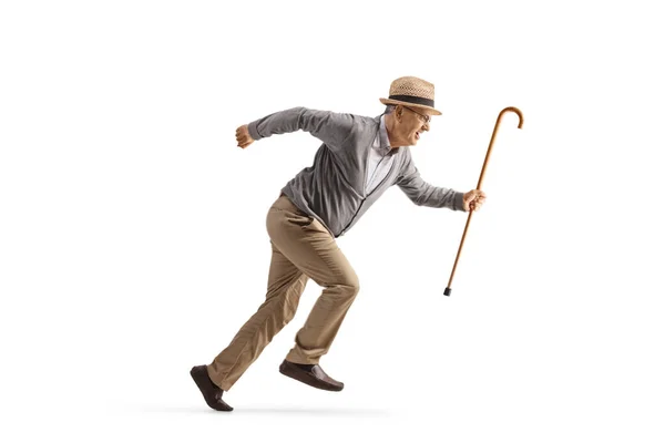 一个拿着手杖在白色背景上跑得很快的老人的全长侧面照片 — 图库照片