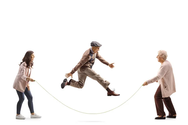老年妇女和年轻妇女牵着绳子 老年男子跳过 与白人背景隔离 — 图库照片