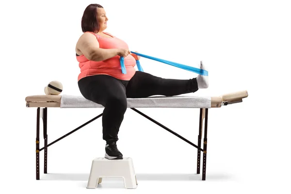Overweight Woman Sitting Therapy Bed Exercising Resistance Band Isolated White — Stock Photo, Image