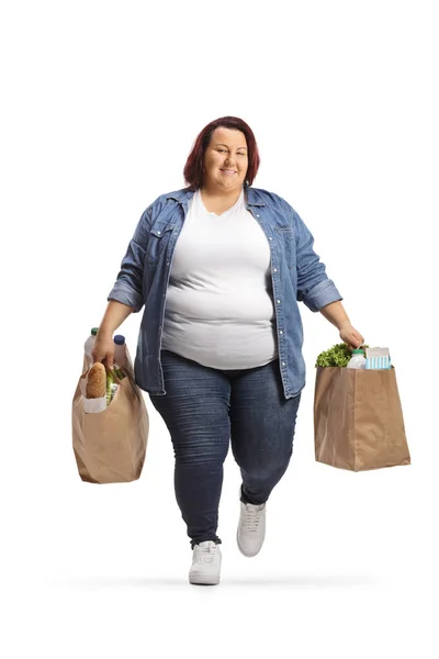 超重的年轻女子背着购物袋 独立行走在白色的背景下 — 图库照片