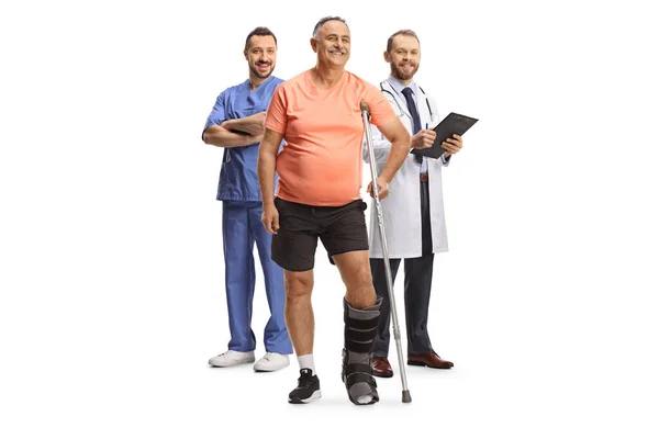 Full Length Portrait Cheerful Mature Male Patient Crutches Physicians Standing — Stock Photo, Image