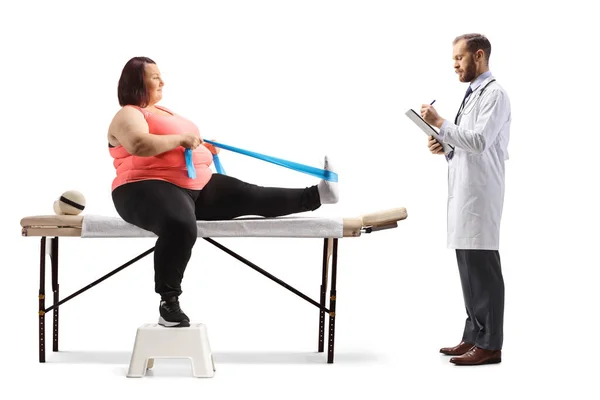 Overweight woman exercising with a stretching band and doctor writing a document isolated on white background