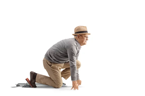 Vollständige Profilaufnahme Eines Älteren Mannes Der Auf Startblöcken Kniet Isoliert — Stockfoto