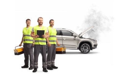 Beyaz arka planda izole edilmiş bir SUV 'un önünde duran yansıtıcı yelekli yol yardım ekibi.