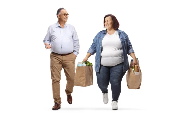 提着购物袋走来走去和一个白人背景的成熟男人说话的超重女人 — 图库照片