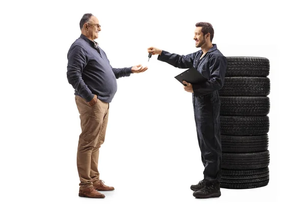 Maschinist Gibt Autoschlüssel Einen Reifen Mann Isoliert Auf Weißem Hintergrund — Stockfoto