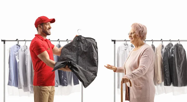 Young man delivering dry cleaned clothes to an elderly lady isolated on a white backgroun