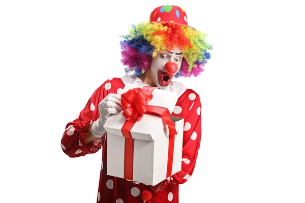 小丑偷看一个被白色背景隔开的礼物盒 — 图库照片