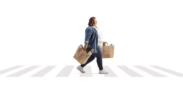 白い背景に隔離された歩行者横断歩道を歩くと食料品袋を持つ腐敗した女性 — ストック写真
