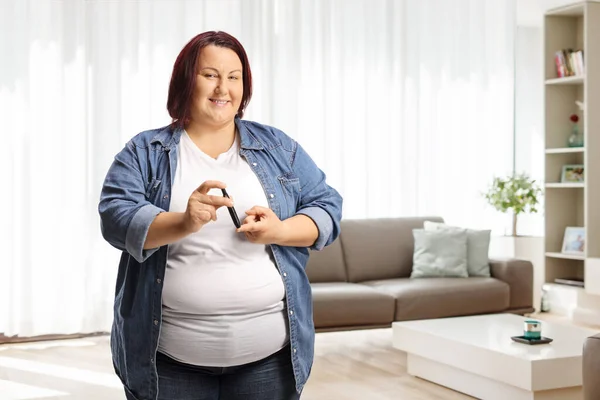 Übergewichtige Frau Stochert Hause Mit Insulinstift Finger Und Schaut Kameramann — Stockfoto