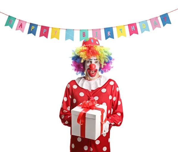 在一个被白色背景隔离的生日派对上 兴奋地拿着礼物盒的小丑 — 图库照片