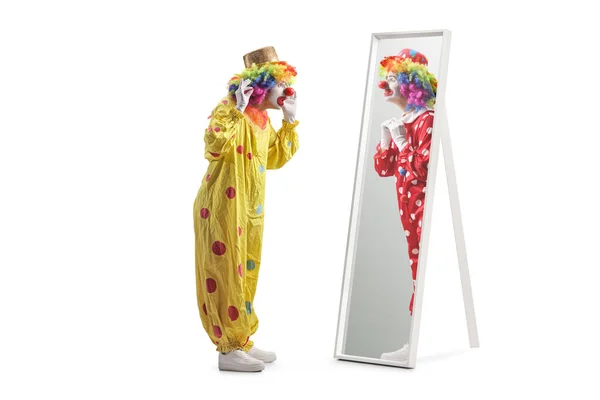 身着黄色服装的小丑站在镜子前 看着穿着红色服装 被白色背景隔离的小丑 — 图库照片